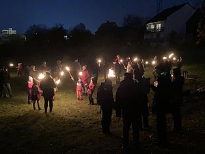 Das Bild zeigt einen abendlichen Spaziergang mit Fackeln aus 2022